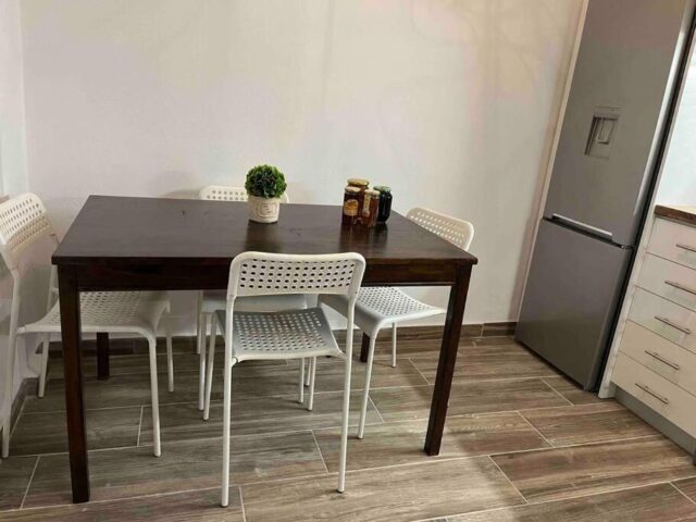 Kitchen dining area with wooden table and fridge in Pavliani Oiti – κουζίνα με ξύλινο τραπέζι και ψυγείο στην Παύλιανη Οίτης