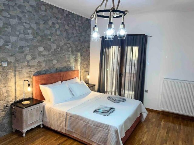 Bedroom with double bed and stone wall in Pavliani Oiti – υπνοδωμάτιο με διπλό κρεβάτι και πέτρινο τοίχο στην Παύλιανη Οίτης, ενοικιαζόμενη κατοικία